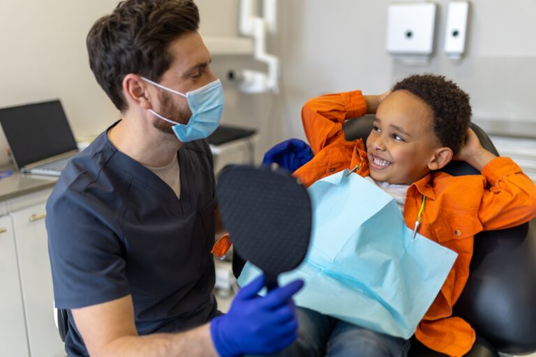 Pediatric dentist comforting an anxious boy before treatment, promoting child-friendly dental care and anxiety-free visits