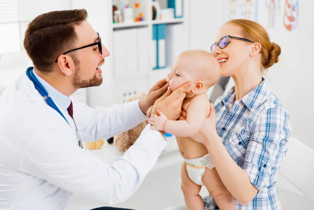 Mother holding her toddler during a pediatrician visit, highlighting a routine checkup and comprehensive child health assessment