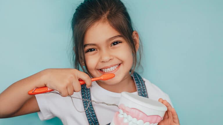 Child brushing teeth to prevent cavities, promoting healthy oral hygiene habits